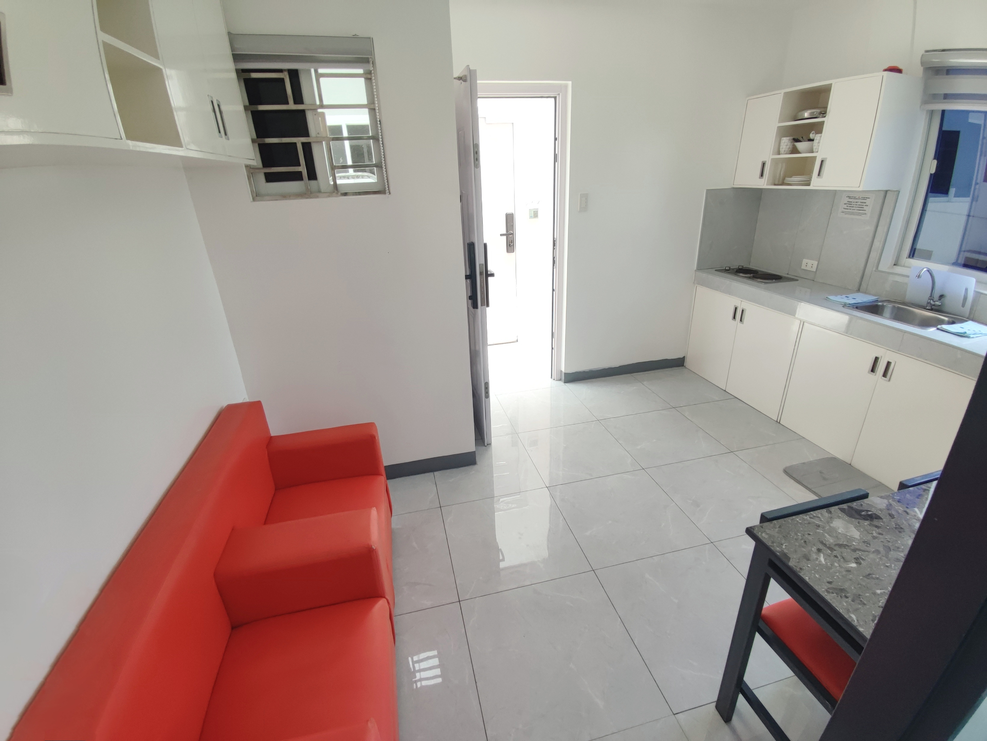 Doctor A CondoSuites living area with sofa and kitchenette