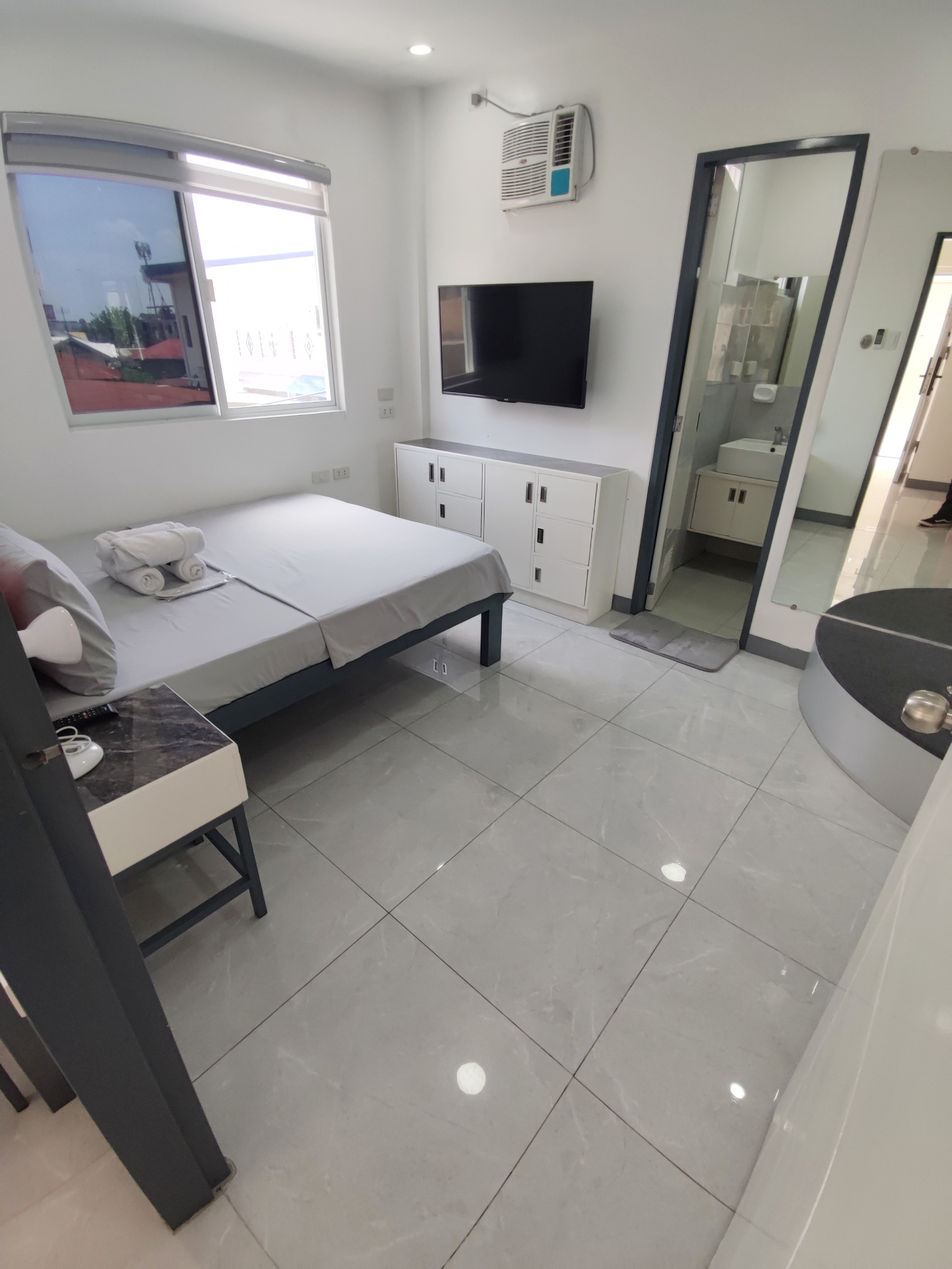 Doctor A CondoSuites bedroom with window view and wall-mounted television